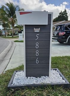 a black and white mailbox sitting in the grass