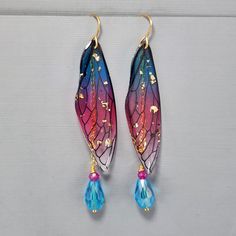 "Fairy Wing Earrings Blue Wing Pink Wing Fairy Wings Earrings Blue Crystal Teardrop Earrings Gold Flake Wings Dragonfly Wing Earrings These super fun light weight earrings are so pretty.  I connect the resin wings to the ear wire and hang a glass tear drop and glass crystal from a gold plated chain.  The beads are wire wrapped for added security.  The earrings hang 2 3/4\" from the gold plated ear wires.   They ship with rubber backs to prevent loss. They ship in a delightful organza bag perfect for gift giving." Fairy Wings Earrings, Drawing Body Proportions, Fairy Wing Earrings, Teardrop Earrings Gold, Wings Earrings, Crystal Teardrop Earrings, Dragonfly Wings, Gold Flake, Blue Wings