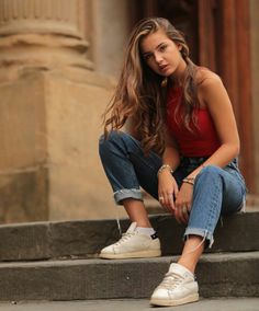 a young woman sitting on steps with her legs crossed