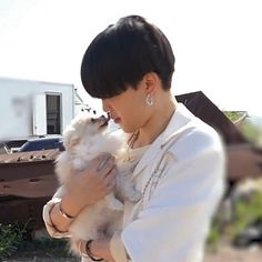 a woman holding a small white dog in her hands