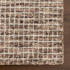 a brown and white rug on top of a wooden floor