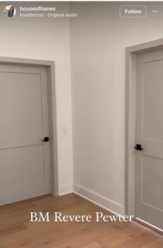 an empty room with two white doors and wood flooring in front of the door