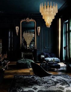 a living room filled with furniture and a chandelier hanging from the ceiling in front of a mirror