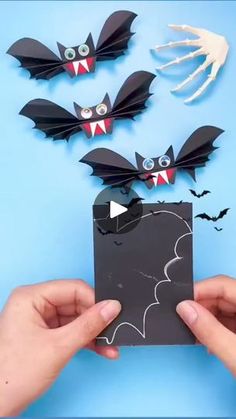 someone is holding up a card with bats on it and two hands are reaching out