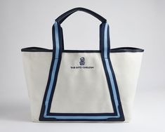 a white and blue tote bag sitting on top of a table