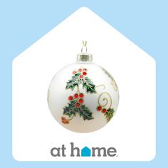 a white ornament with holly and red berries on it's side in the shape of a house