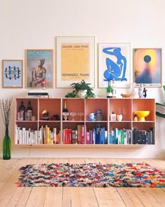 a living room filled with lots of furniture and bookshelves next to a plant