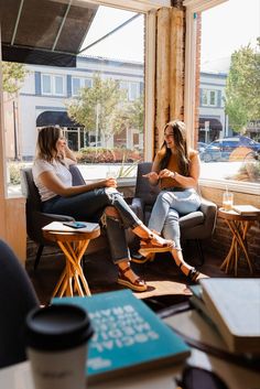 two women sitting in chairs talking to each other