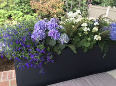 a planter filled with lots of purple and white flowers