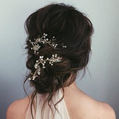 the back of a woman's head wearing a white veil with flowers on it