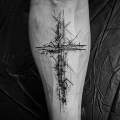 a black and white photo of a cross tattoo on the right leg, with lines running through it