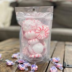 a bag filled with candy canes on top of a wooden table