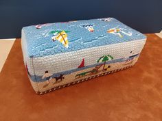 a blue and white foot stool with beach scenes on it