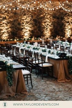 an indoor venue with tables and chairs set up for a wedding reception at the stone wall