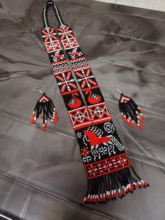 a black and red beaded scarf with tassels on it's sides