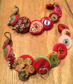 a bunch of buttons that are sitting on a wooden table with some keychains