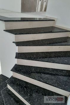 a set of stairs with black marble treads