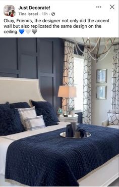 a bedroom with blue and white decor on the walls, bed in front of a chandelier