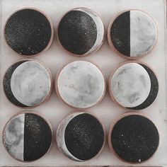 nine moon cookies with black and white frosting on them are arranged in a square pattern