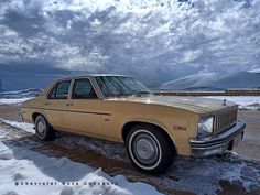 an old car is parked in the snow