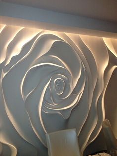 a large white rose is on the wall behind a table and chairs in front of it