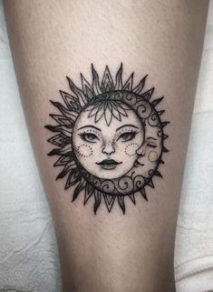 a sun and moon tattoo on the leg, with black ink in it's center