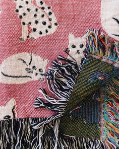 a close up of a blanket with cats on it and fringes around the edges