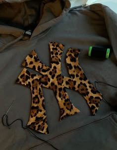 an animal print cross is on top of a hoodie