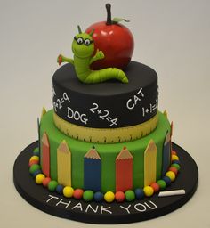 a birthday cake with a caterpillar on top and a teacher's scale