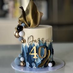 a birthday cake decorated with blue and gold decorations