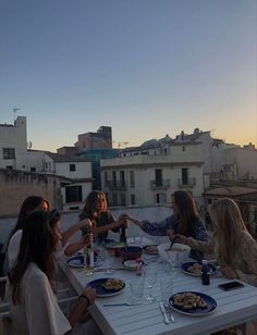 four women sitting at a table with plates of food