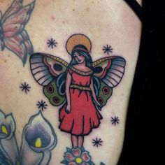 a woman's back with an angel and flowers tattoo on her left side ribcage