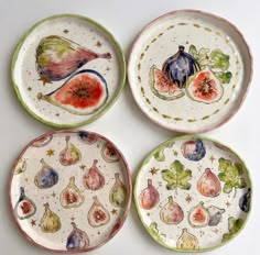 four plates with different designs on them sitting next to each other