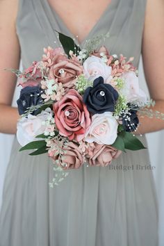 a bridesmaid holding a bouquet of flowers in her hands and wearing a gray dress