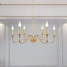 a chandelier hanging from the ceiling in a room with white walls and flooring