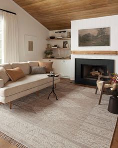 a living room filled with furniture and a fire place in the middle of a room