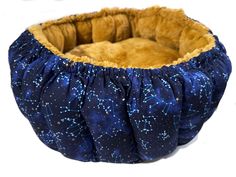 a blue and gold dog bed with stars on the bottom, in front of a white background