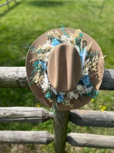 A beautiful handmade blue and white floral crown on a chestnut colored cowboy hat of exquisite quality! Floral Cowboy Hat, Brown Felt Hat For Spring Country Events, Handmade Brown Hat Bands For Kentucky Derby, Handmade Ranch Hats For Spring, Handmade Hat Bands For Ranch In Spring, Blue Country Style Felt Hat For Country Events, Handmade Brown Hat Band For Spring, White Floral Crown, White Cowboy Hat