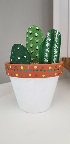 there is a potted plant with green cactuses in it