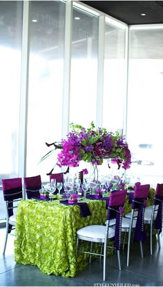 the table is set with purple and green linens