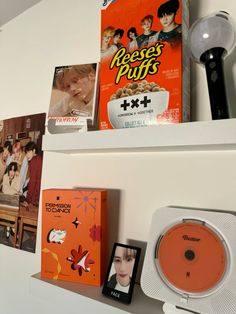 there are many books and movies on the shelf above the stereo system, along with an mp3 player