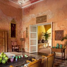 a living room filled with furniture next to a painting on the wall above a table