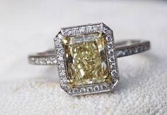 a fancy yellow diamond ring on a white cloth