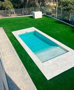 an artificial swimming pool surrounded by grass