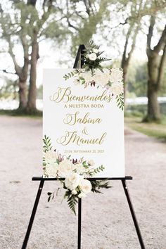 a sign with flowers and greenery on it