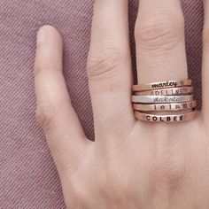 The Maryl Set This stackable mixed metals ring set includes five rings that can be personalized with names, dates, or symbols. This pretty stacking set includes the following: -a 2 mm rose gold filled name ring in uppercase thin block font -a 2 mm yellow gold filled name ring in lowercase bold cursive font -a 2 mm fine silver name ring in lowercase cursive font -a 2 mm rose gold filled name ring in uppercase bold block font -a 2mm yellow gold filled name ring in lowercase typewriter font We reco Bold Cursive Font, Stackable Name Rings, Five Rings, Block Fonts, Block Font, Multiple Rings, Typewriter Font, Name Ring, Cursive Font