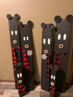 two black bear skis are decorated with red and white plaid bows, nose holes in the snow