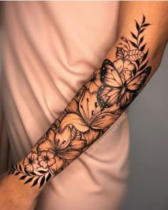 a woman's arm with flowers and butterflies on it