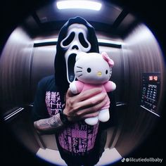 a person holding a hello kitty stuffed animal