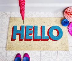 a door mat with the word hello painted on it next to shoes and umbrellas